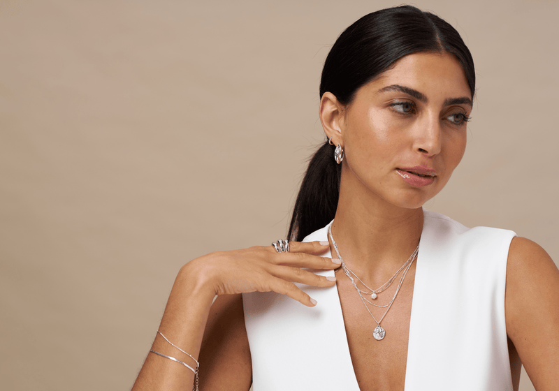 Model wearing silver necklaces and other jewellery from Orelia