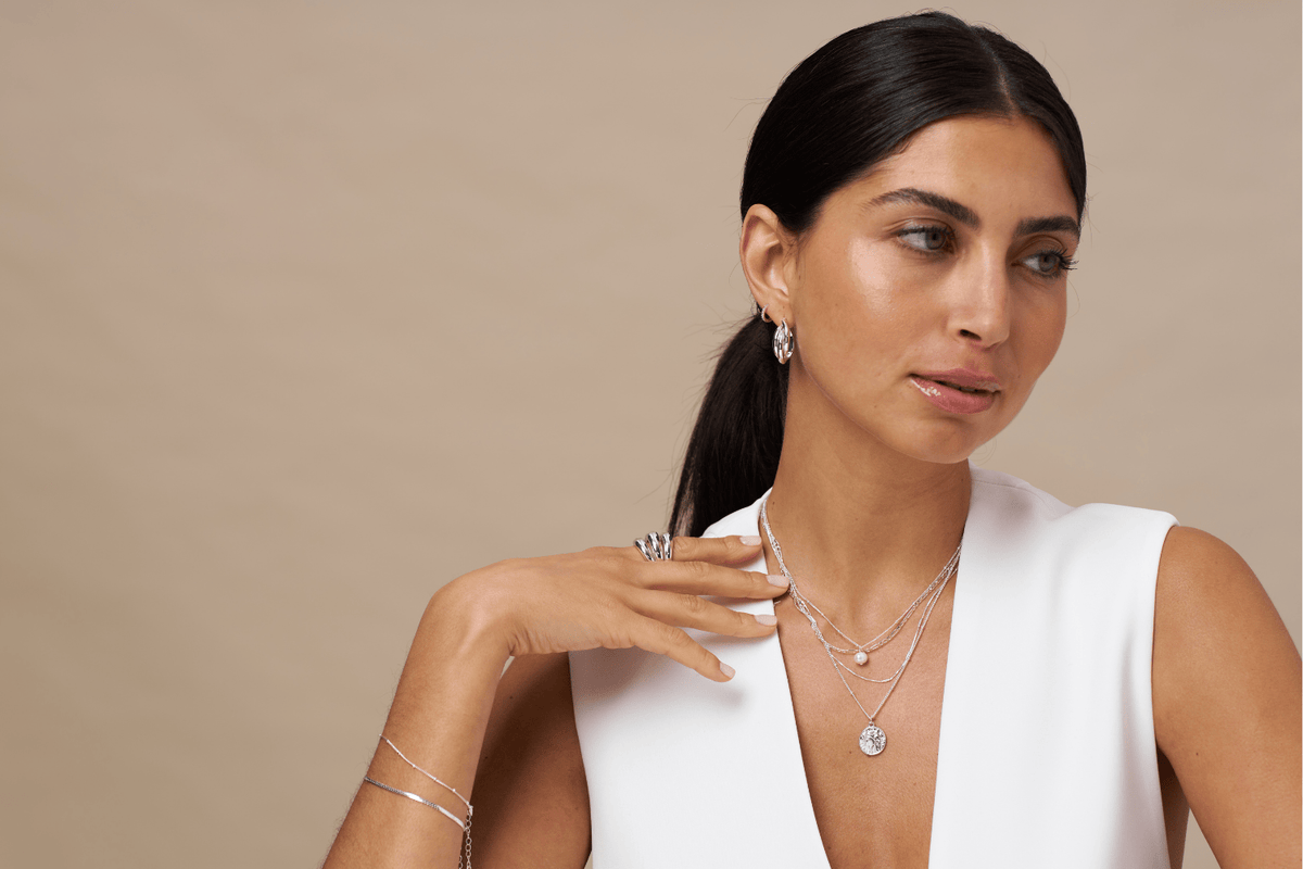 Model wearing silver necklaces and other jewellery from Orelia