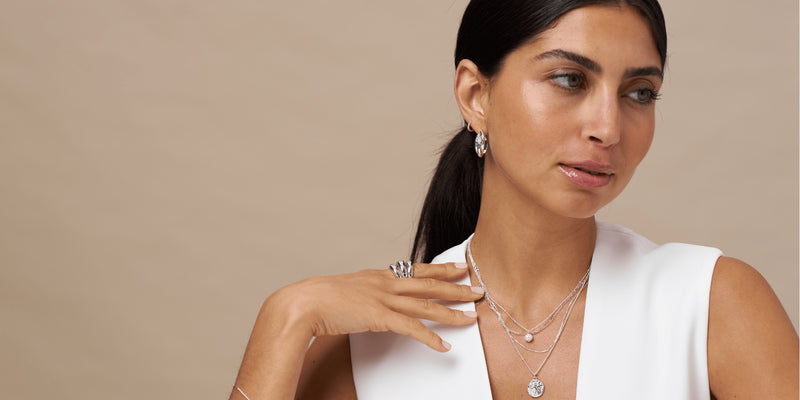 Model wearing silver necklaces and other jewellery from Orelia