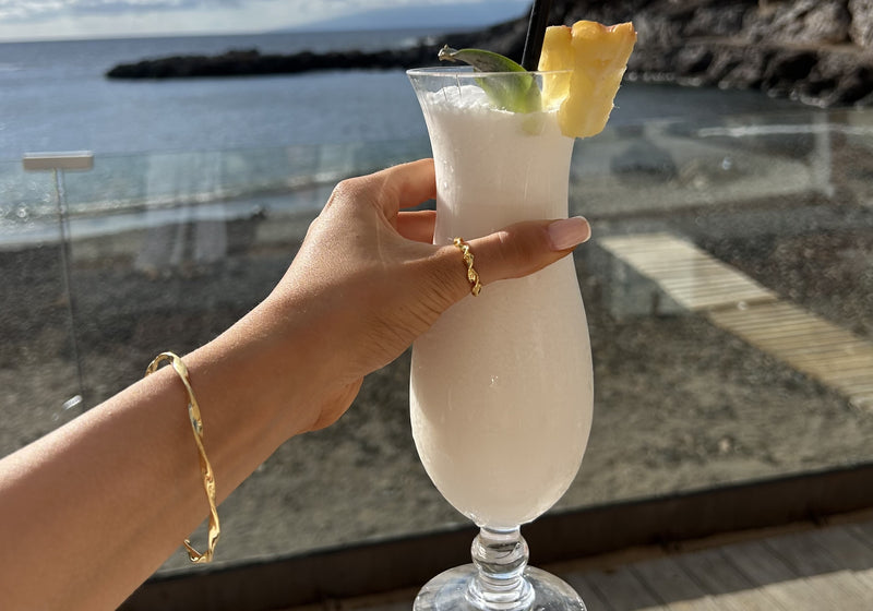 model_holding_cocktail_with_gold_bracelet_and_ring