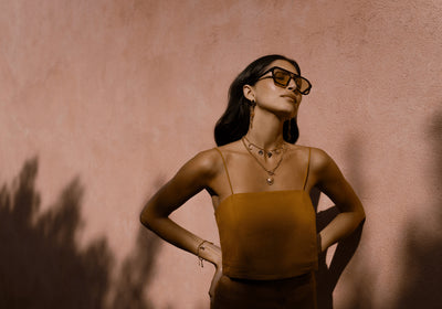 Model wearing Orelia Statement jewellery pieces, necklaces and earrings in gold. 